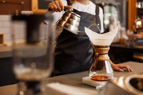 Pouring water from a gooseneck kettle into a Chemex